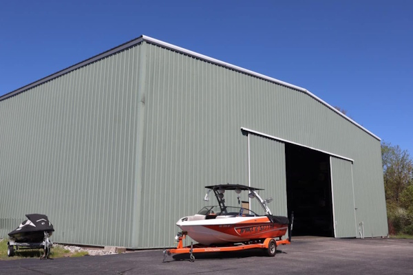 Orange Malibu boat beside an open bay door